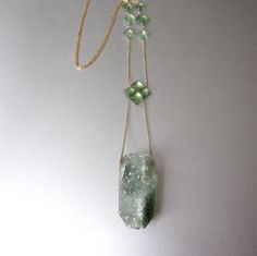 A woven clover of light green emeralds suspends a chunky quartz crystal, covered in sparkling naturally green druse. Six more emeralds accent the fine cable chain. The necklace is 18" and the drop from top of clover to bottom of crystal pendant is 3". The necklace is finished with a spring ring clasp.Check out Jenco Studios at: www.jencostudio.com and www.facebook.com/jencostudios for work in sterling silver, new work previews, info on upcoming sales and signing up for the Jenco Studio mailing l Unique Faceted Green Jewelry, Unique Green Faceted Jewelry, Fine Jewelry With Green Amethyst, Green Faceted Spiritual Jewelry, Spiritual Green Faceted Jewelry, Green Mineral Crystal Pendant Jewelry, Unique Green Jewelry With Mineral Crystal, Green Amethyst Jewelry With Natural Stones, Green Amethyst Necklace For Gift