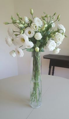 a vase filled with white flowers on top of a table