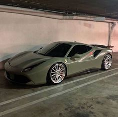 a green sports car parked in a parking garage