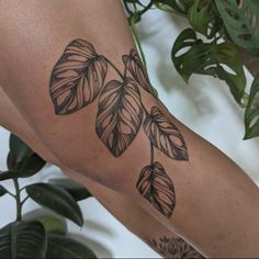 a woman's arm with leaves on it