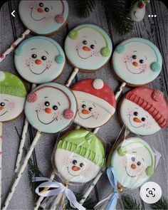 decorated cookies with frosting and decorations on sticks next to christmas tree branches, snowman hats, and candy canes