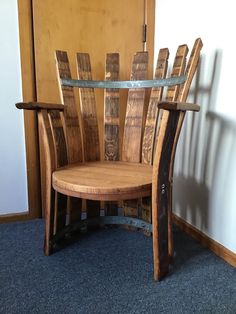 a wooden chair sitting in front of a wall with a metal bar on it's back