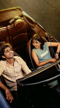 a man and woman sitting in a car seat