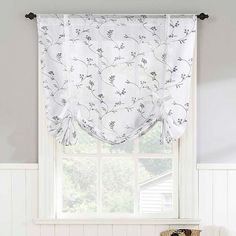 a kitchen window with a flowered valance hanging over it