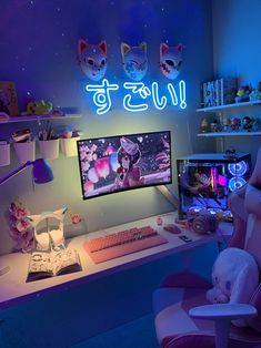 a computer desk with a cat sitting on it in front of a neon sign that says hello kitty