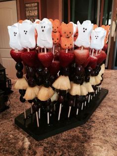 there are many halloween treats arranged on the table with fruit and marshmallows