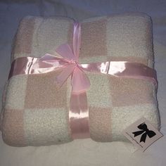 a blanket with a pink ribbon tied around it