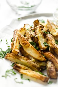 a white plate topped with french fries covered in herbs