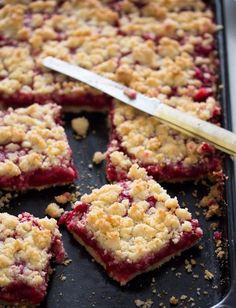 berry crumb bars on a baking sheet with a knife