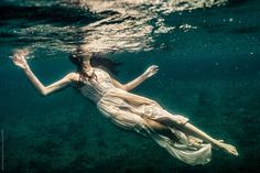 a woman floating in the water with her arms outstretched