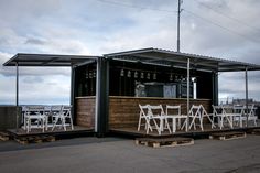 an outdoor bar set up with white chairs