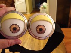 someone is holding two minion eyes in front of their camera lens holder, which has an eyeball on it