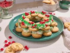 a green plate topped with cookies covered in frosting and sprinkles on top of a table