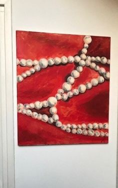 a painting is hanging on the wall next to a white door with pearls in it