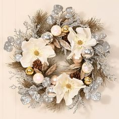 a christmas wreath with white flowers and silver ornaments