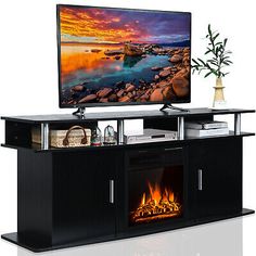 a flat screen tv sitting on top of a wooden entertainment center next to a fire place