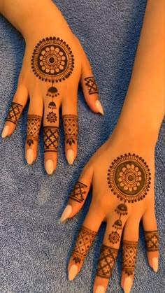 two hands with henna tattoos on them