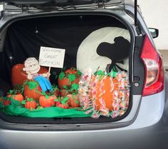 the trunk of a car is decorated with pumpkins and decorations