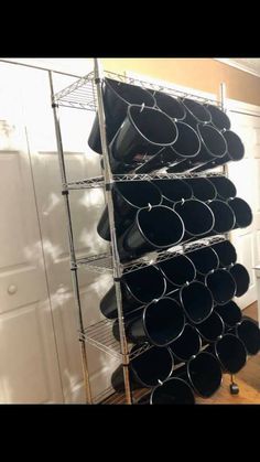 a stack of black pots sitting on top of a metal rack