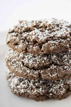 three chocolate cookies with powdered sugar on top