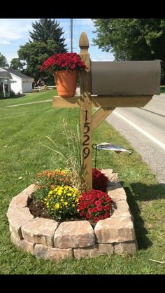 a mailbox is decorated with flowers in a flower bed