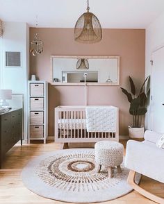 a baby's room with a white crib, chair and rug on the floor