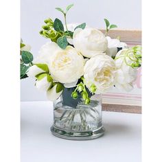 two vases filled with white flowers on top of a table