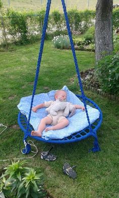 a baby laying on top of a blue swing