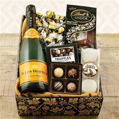 a bottle of champagne, chocolates and truffles in a box on a table