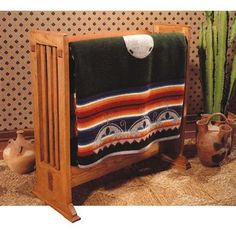 a towel rack with two towels hanging on it's sides, next to a potted plant