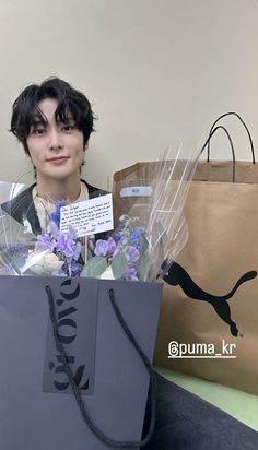 a woman holding a shopping bag with flowers in it