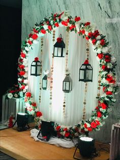 a round mirror with lanterns and flowers around it