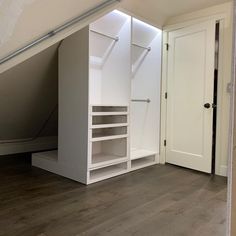 an empty room with white closets and shelves