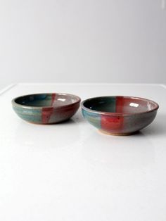 two bowls sitting next to each other on a white counter top in front of a wall