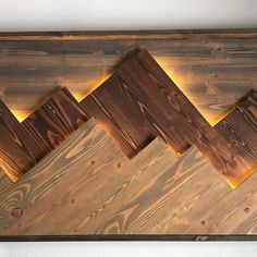 wood planks are lined up in the shape of zigzags on a wall