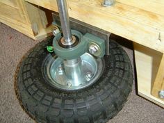 the wheel is attached to the wooden bench with two screwdrivers on it,