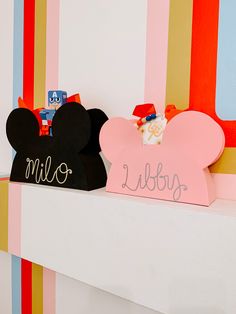 two mickey mouse ears are sitting on top of a mantle with the name minnie written on it