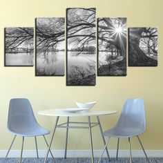 a dining room table with four chairs and a wall mounted art piece on the wall