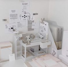 a white desk topped with lots of papers and binders