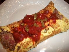 an omelet with meat and sauce on a white plate