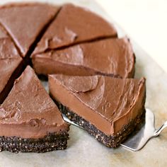 there is a chocolate cake on the table with a slice cut out and ready to be eaten