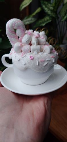 a small cup filled with marshmallows on top of a white saucer