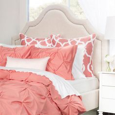 a bed with pink and white comforters in a bedroom