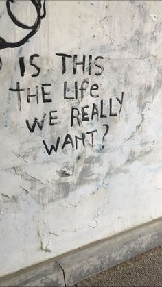 graffiti on the side of a building that says is this the life we really want?