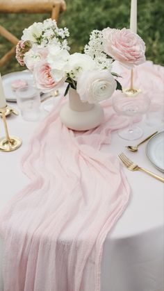 the table is set with pink and white flowers