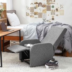 a chair that is sitting in front of a bed with a laptop on top of it