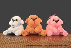 three small stuffed animals sitting next to each other on top of a wicker table