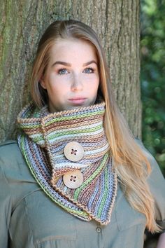 a woman standing next to a tree wearing a scarf