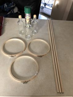 the table is set up with three empty glass bottles and two round wooden dows