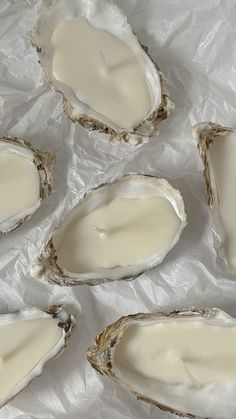 six oysters are sitting on wax paper